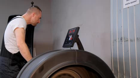 mechanic performing tire balancing in an auto service