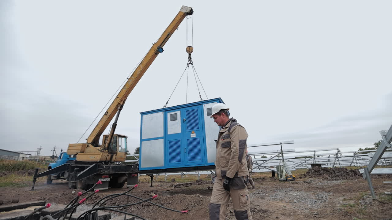 Crane lifting electrical equipment for solar panel installation