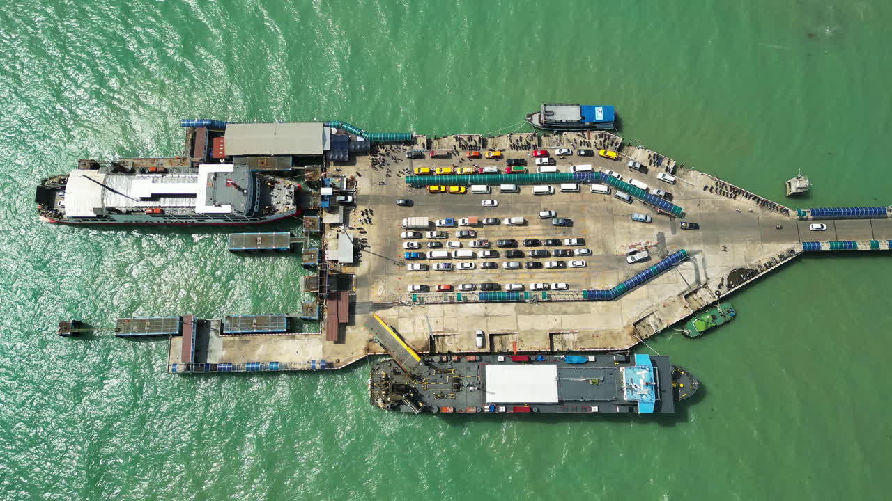 Aerial top down shot of parking Cars on Nathon Pier with ferry ship during sunny day in Koh Samui - Cars left pier from platform