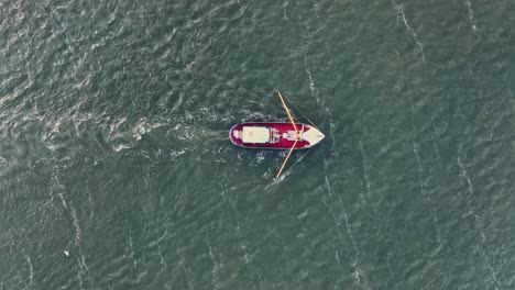 Drone-topdown-shot-of-a-Fishers-boat-dragging-the-nets-thru-the-water