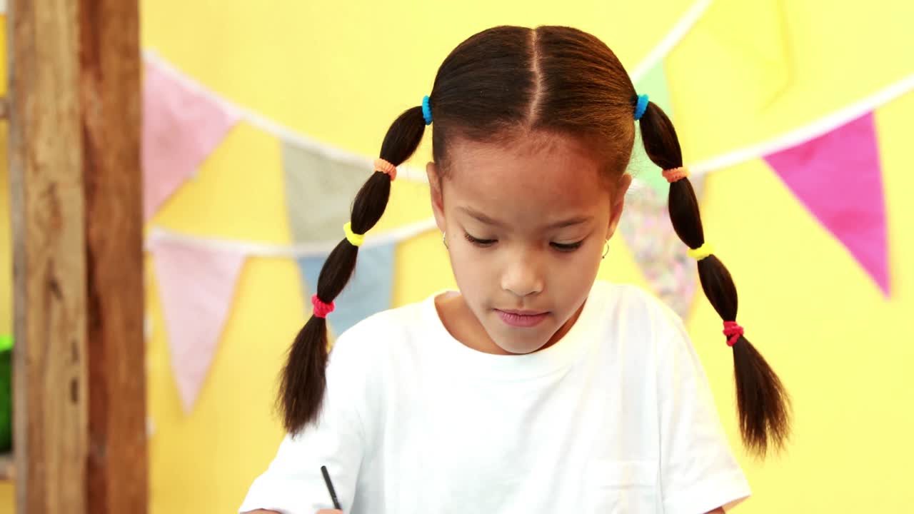 작은 소녀가 그림을 그리고 있습니다.