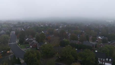 drone footage circling over a large neighborhood in the morning on a foggy day.