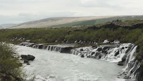 toma panorámica e inclinación de la increíble cascada barnafoss ubicada en islandia, europa
