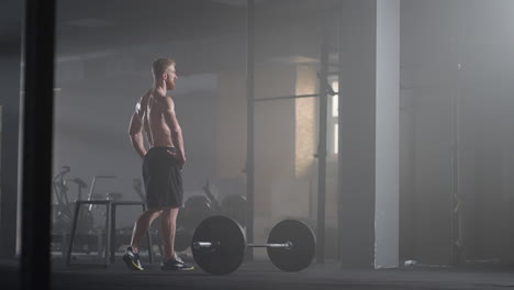 an athlete exhausted by training in the gym after performing the exercise rests and gains strength. a dense strong man recovers during a workout