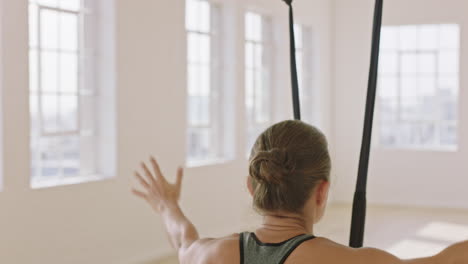 Aerial-Yoga-Frau-übt-Stehende-Kopf-an-Knie-Pose-In-Der-Hängematte-Und-Genießt-Einen-Gesunden-Fitness-Lebensstil,-Indem-Sie-Im-Studio-Bei-Sonnenaufgang-Meditation-Trainiert