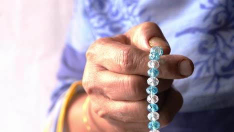 woman holding a beaded bracelet