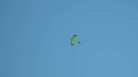 skydiver flying with a parachute in a blue clear sky