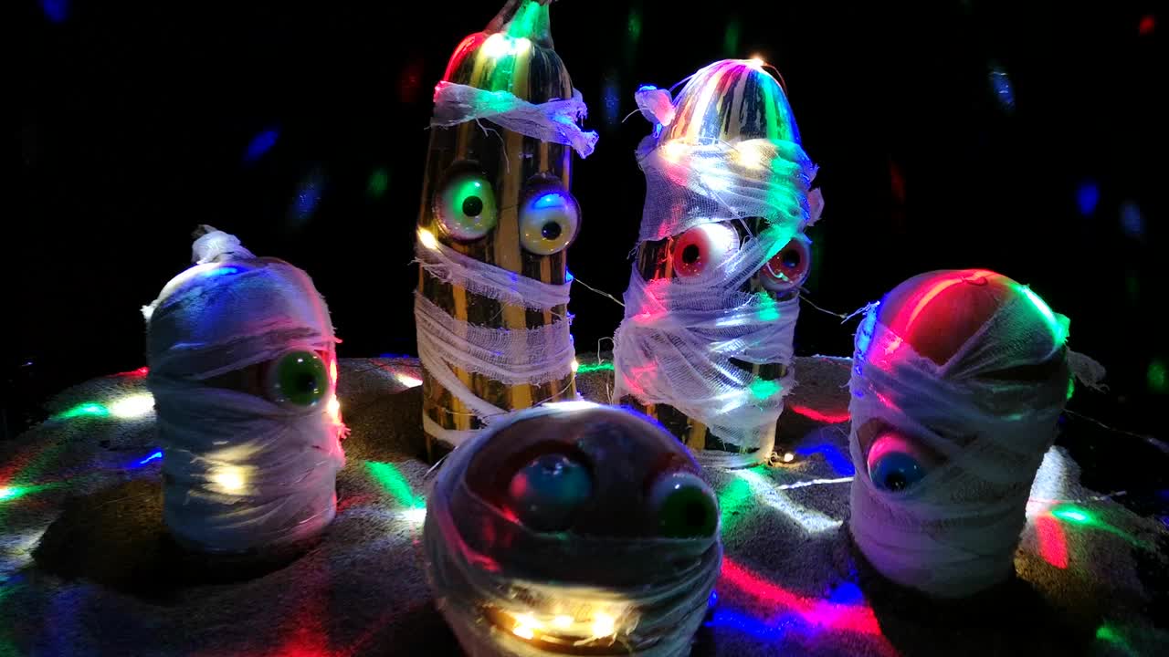 las momias de halloween bailando en los rayos de la pelota de discoteca