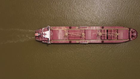 overhead shot of bulk carrier cargo ship sailing in parana river, hidrovia, argentina