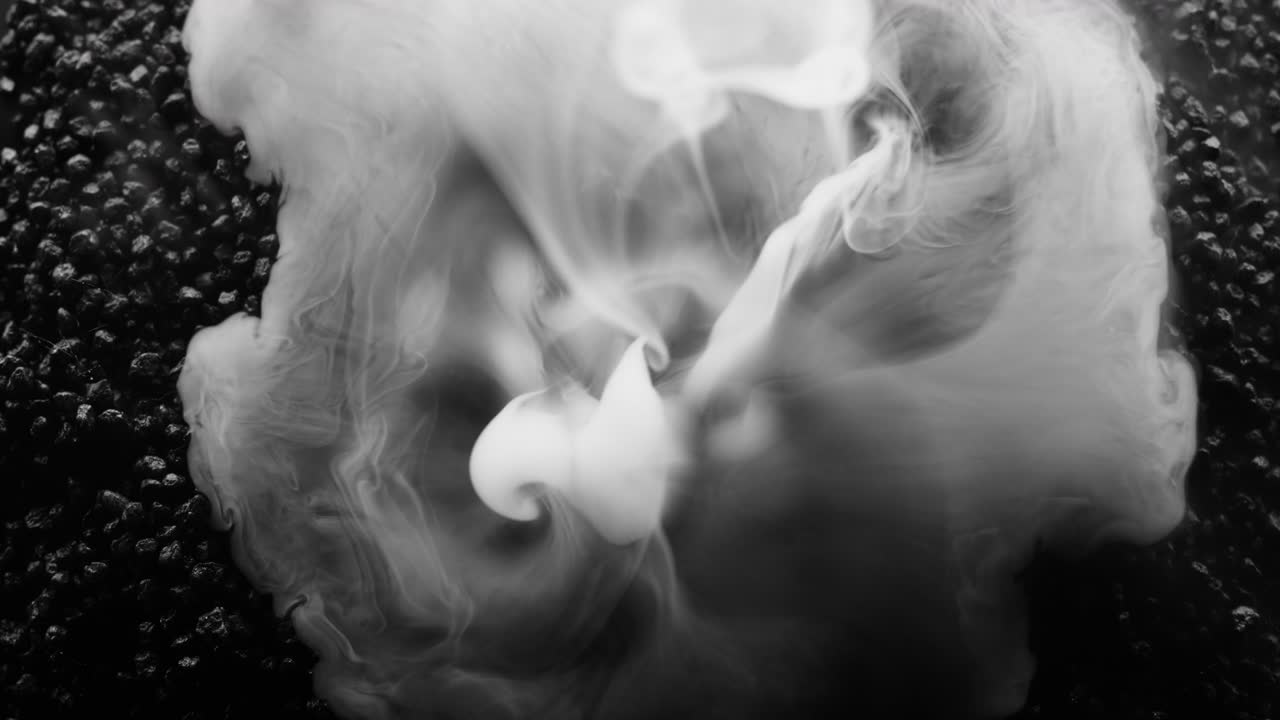 활발한 화산처럼 보이는 어두운 검은 돌에서  연기가 터져 나옵니다.