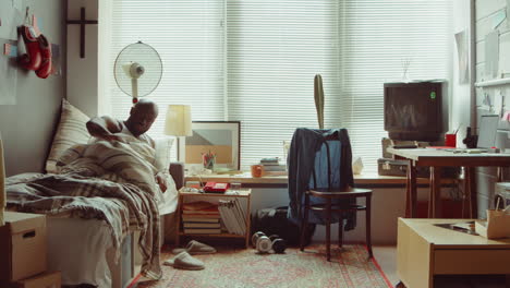 african american man waking up in bedroom at home