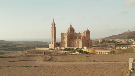 Castillo-De-La-Basílica-De-Ta-Pinu-En-El-País-Seco-De-La-Isla-De-Gozo,-Malta-Im-Color-Marrón-Arena,-Hermoso-Establecimiento-Aéreo-Disparado-Hacia-Adelante