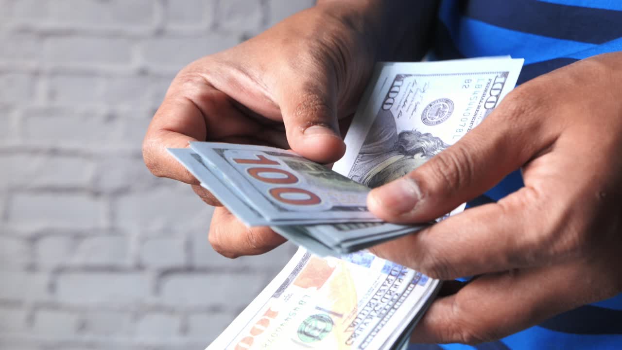 Personne comptant des dollars américains
