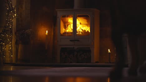 lit fireplace next to christmas decorations