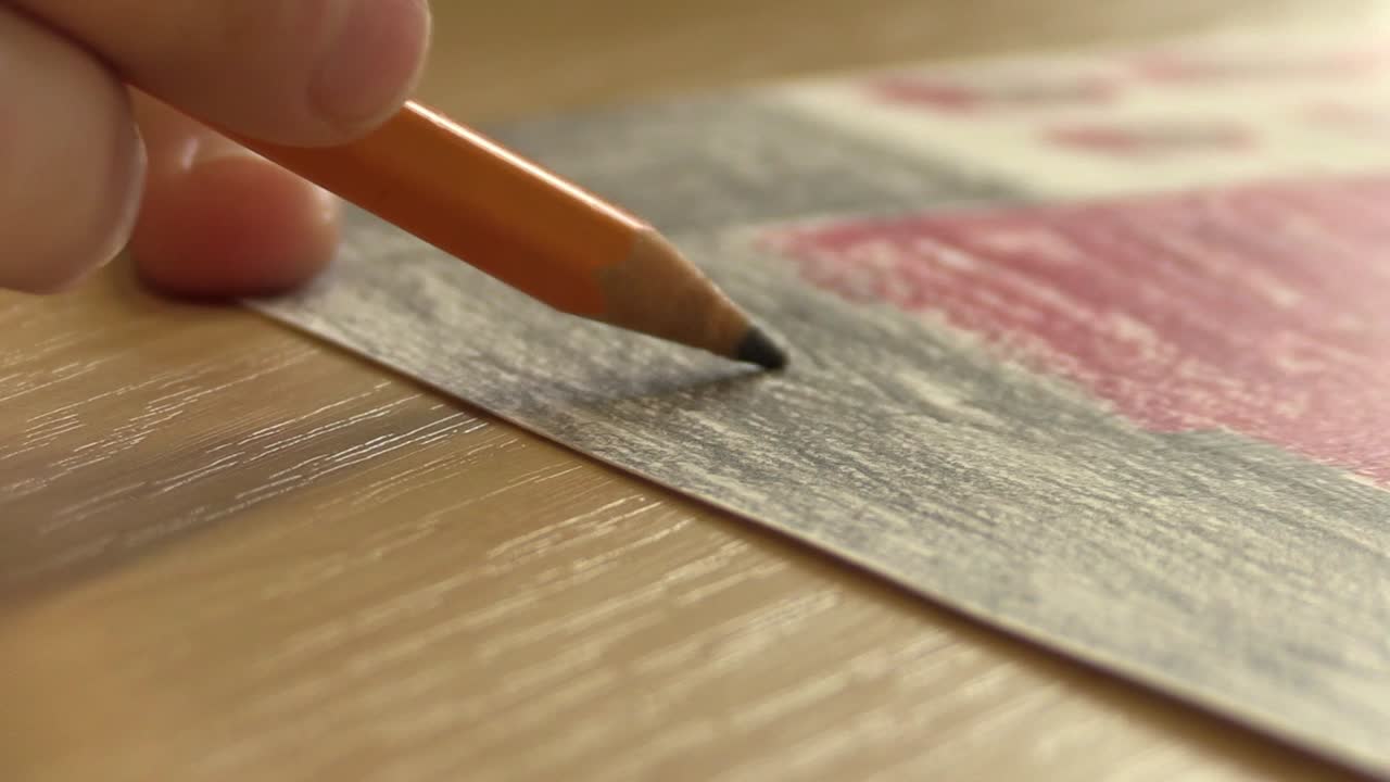 Close-up of a Kid Coloring an Artwork with Grey Pencil
