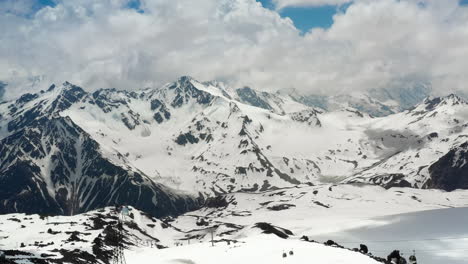 vuelo aéreo a través de nubes montañosas sobre hermosos picos nevados de montañas y glaciares.