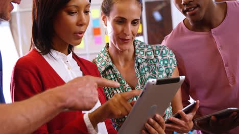 grupo de ejecutivos de negocios discutiendo sobre una tableta digital