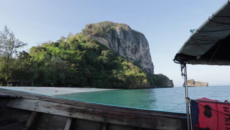 Thai-longtail-boat-arriving-to-anchor-on-the-white-sand-beach-and-turquoise-blue-tropical-water-of-Ko-Poda-Island-in-Krabi-Thailand-on-a-summer-morning