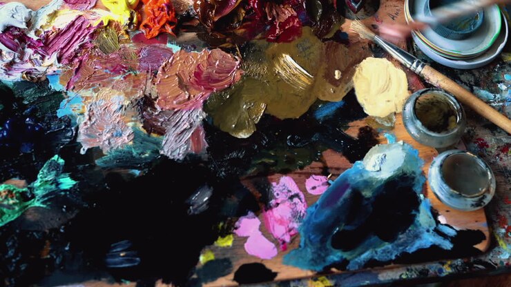 Nahaufnahme einer Frau, die mit einem Pinsel Farbe von einer Palette aufnimmt
