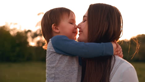 madre y hijo cariñosos abrazándose al aire libre al atardecer. madre y hijo cariñosos abrazados al aire libre en el atardecer durante sus vacaciones de verano