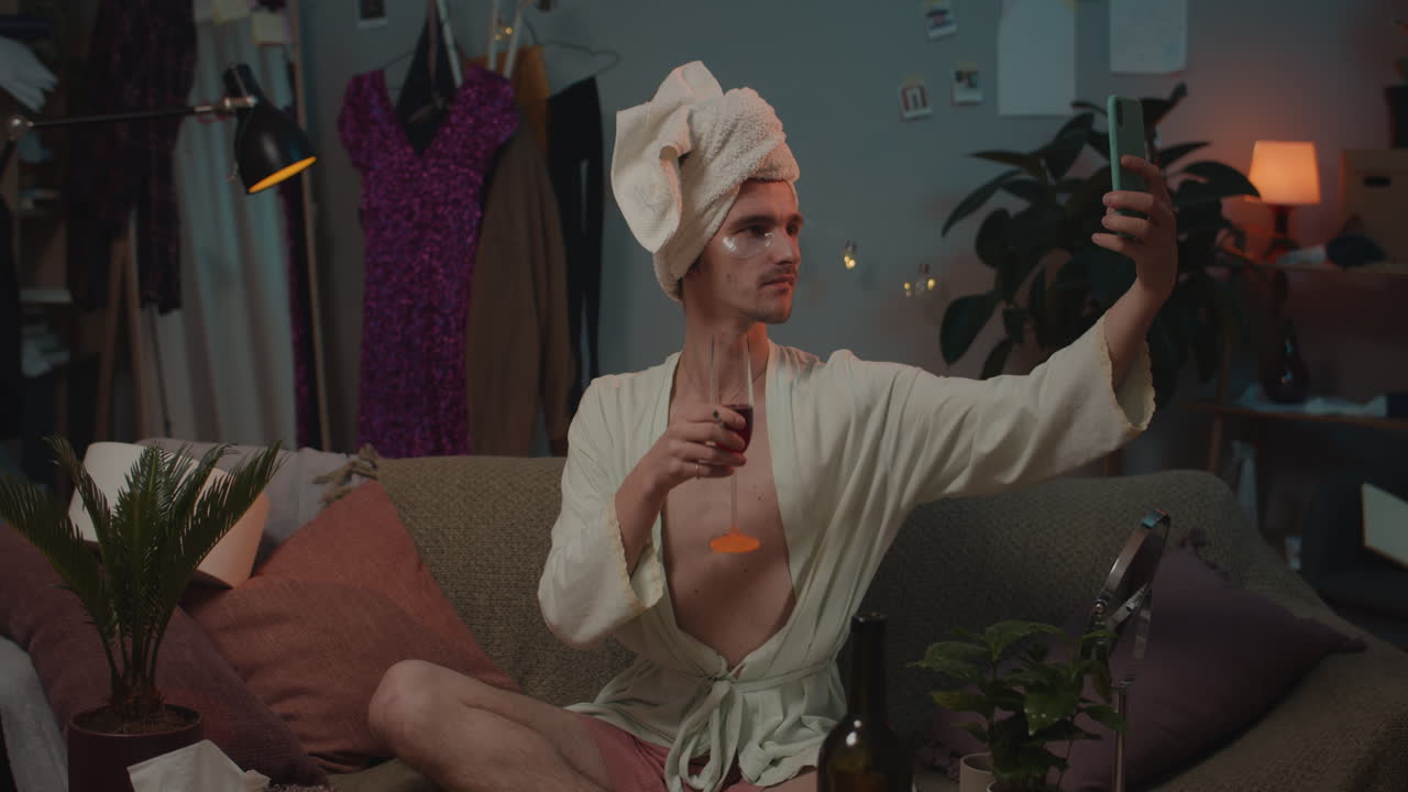 Man relaxing at home with wine and taking a selfie