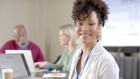 African-american-female-doctor-using-laptop-in-meeting-room-with-copy-space,-slow-motion