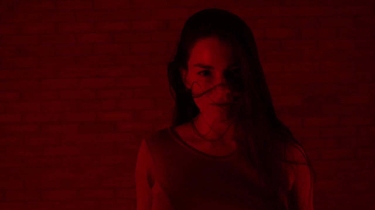 Ballerina affascinante che danza in una stanza rosso scuro all'interno.