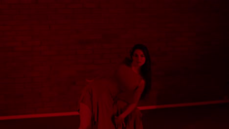 seductive female dancer dancing in a dark red room inside