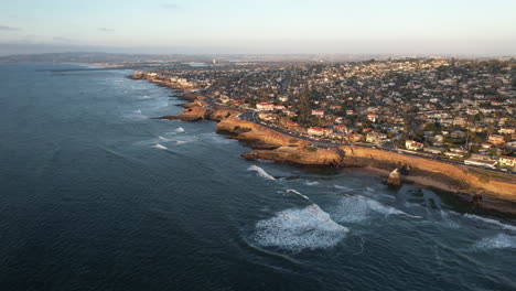 aerial view of san diego cliffs, affluent suburbia and coastline with pacific ocean waves, california usa, high rise drone shot