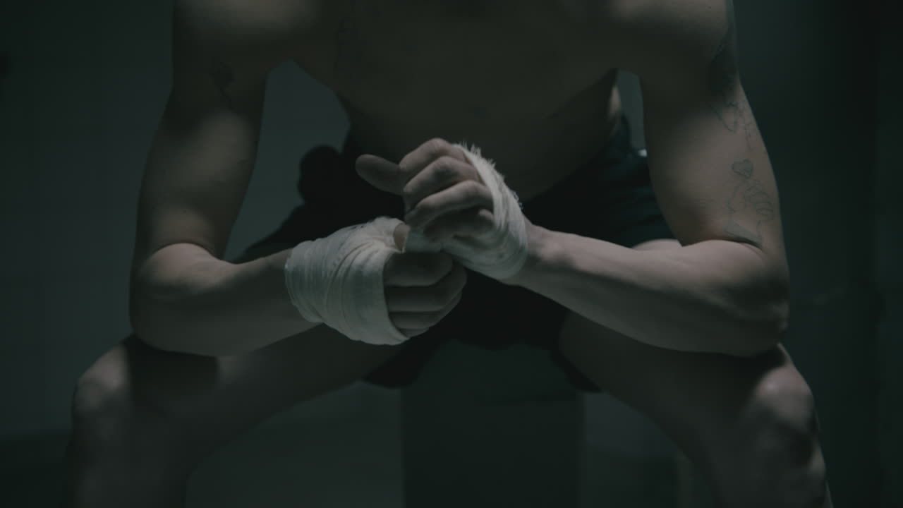 Pale bald skinny man badnages his hands in the creepy old bathroom at night