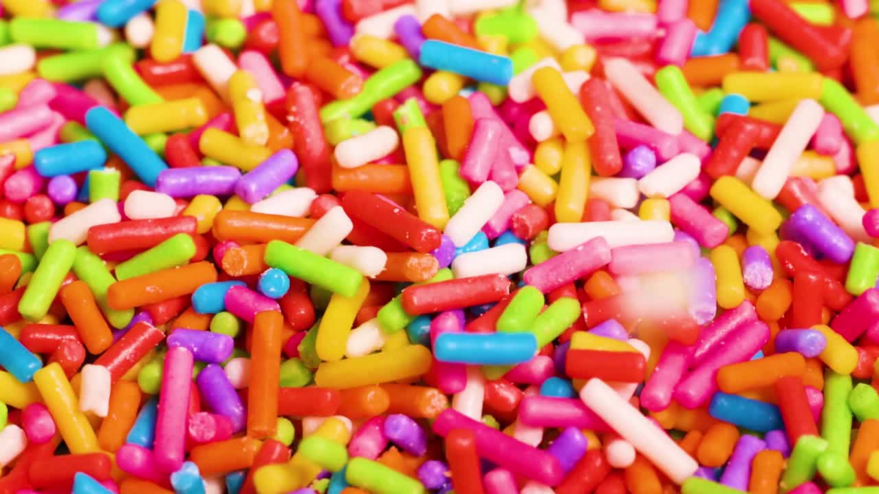 Uno strato denso di zuccherini multicolore riempie l'inquadratura in una vivace macro.
