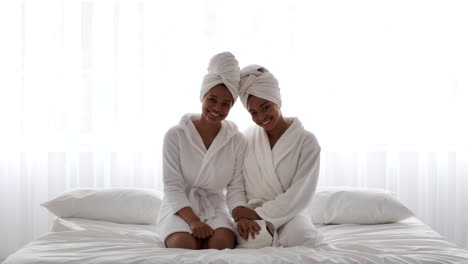 two sisters relaxing in a spa-like bedroom
