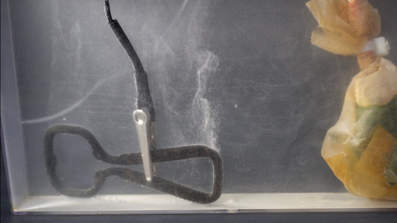 Rusty bottle opener releases bubbles during electrolytic cleaning