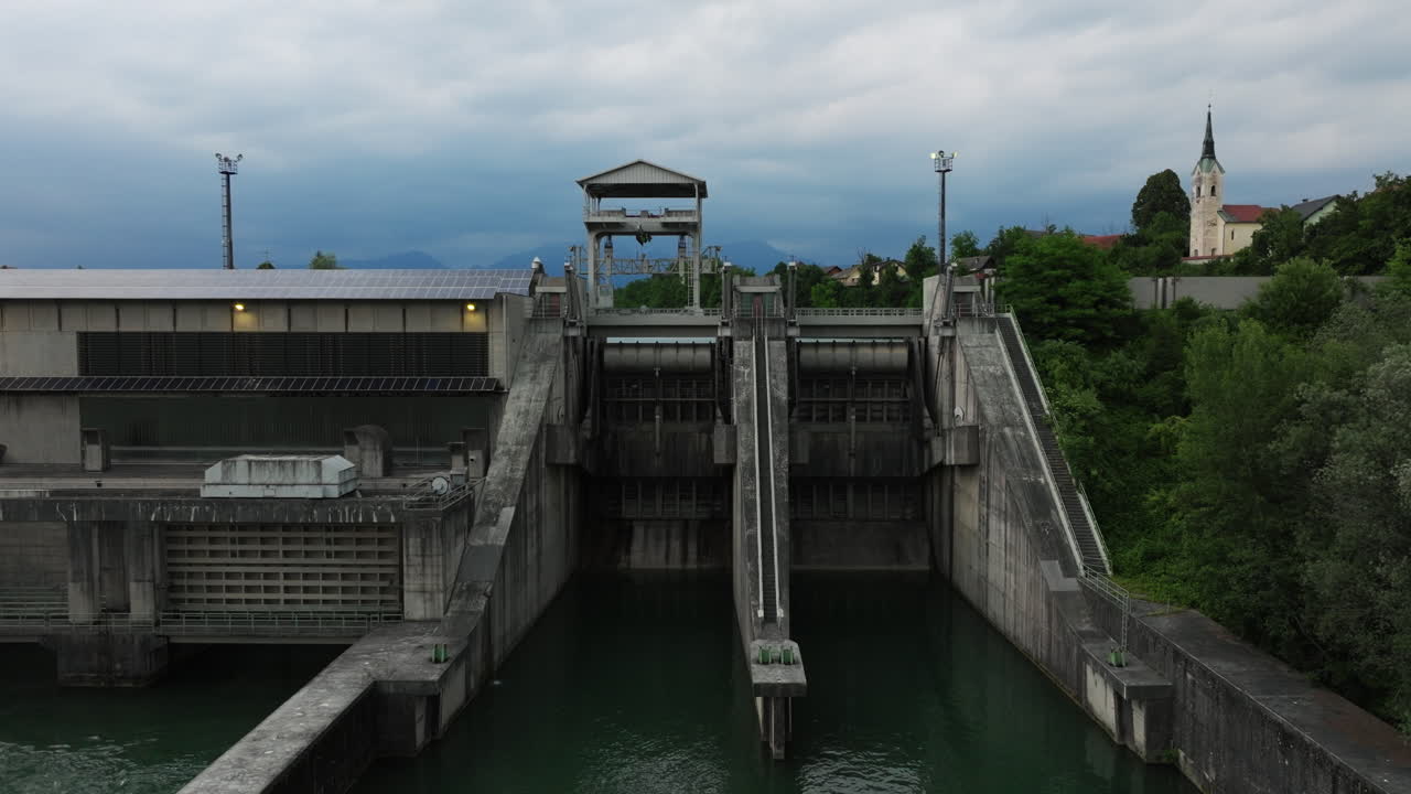 View of the Mavčiče hydroelectric power plant on the Sava River, showcasing renewable energy infrastructure in the Slovenian alpine region.