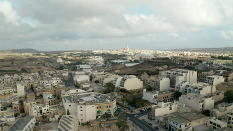 Sich-Schnell-Bewegender-Hyperlapse-über-Der-Insel-Gozo,-Malta-Mit-Kirche-In-Der-Ferne-Und-Bedecktem-Himmel,-Lufttransportwagen