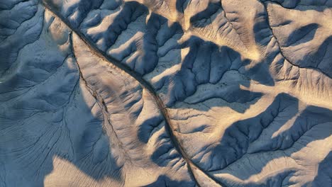 de arriba hacia abajo aéreo hacia adelante sobre el desierto gris en el amanecer dorado, planeta extranjero