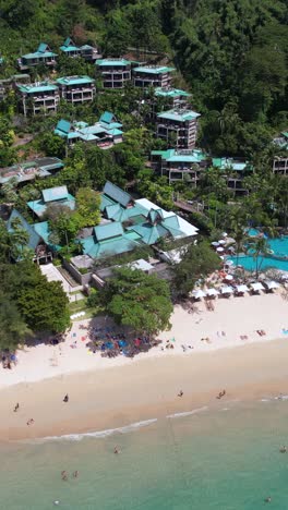 vertical drone shot, luxury villas of tropical resort and beach with white sand