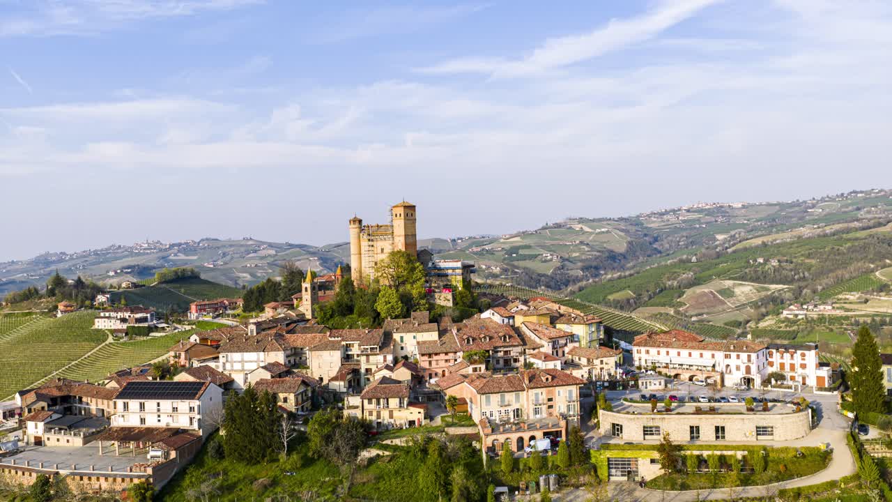 Serralunga d'Alba village and castle standing proudly among rolling Vineyard hills in Italy. aerial