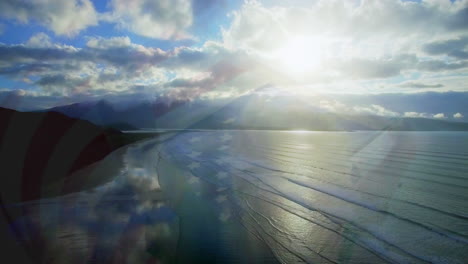 animation of landscape with ocean over caucasian siblings with american flag at beach