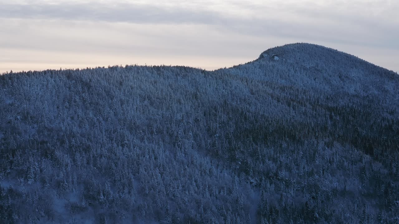 primer plano medio de los picos de las montañas cubiertas de nieve de los municipios del este de quebec, canadá - toma aérea panorámica izquierda