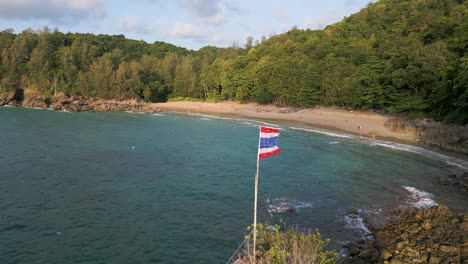 Slow-rotating-drone-over-Thai-flag-at-beautiful-sandy-beach