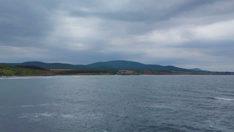 Drone flying above sea to the beach in winter