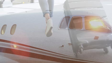 Airplane-against-low-section-of-woman-walking-with-suitcase-in-the-airport