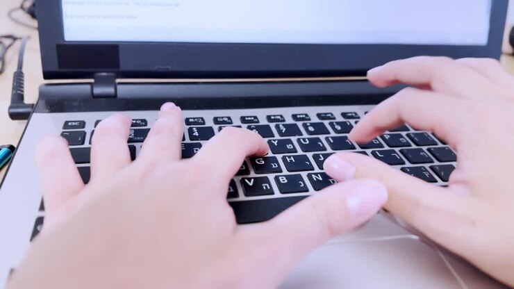 Person Typing on Laptop Keyboard