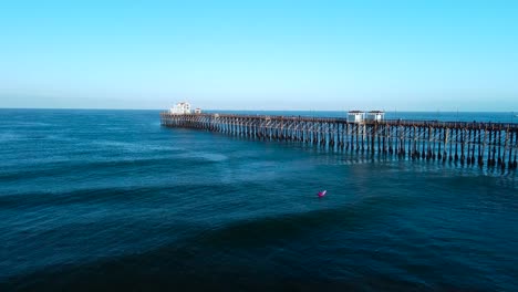 oceanside pier slow pan back with surfer