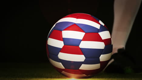 jugador de fútbol pateando la pelota de la bandera holandesa