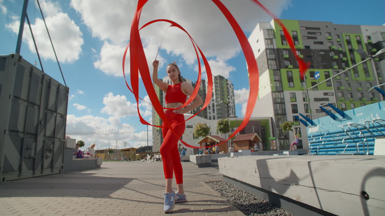Woman Performing Ribbon Dance in Urban Park