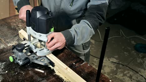 close-up of a carpenter's hand working with an manual electric cutter in a home workshop.