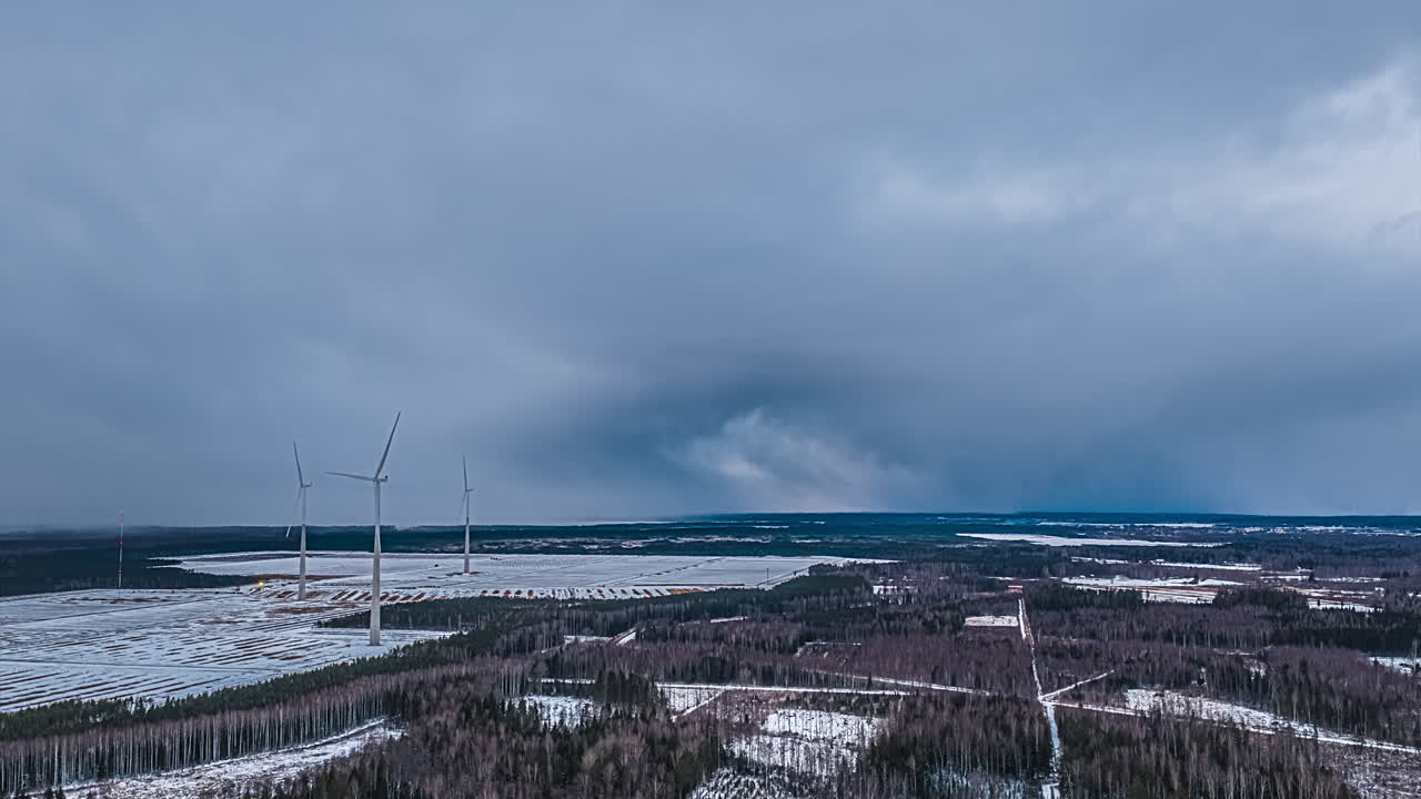 Vintervindmøllepark-hyperlapse med snedækket landskab og dramatisk himmel