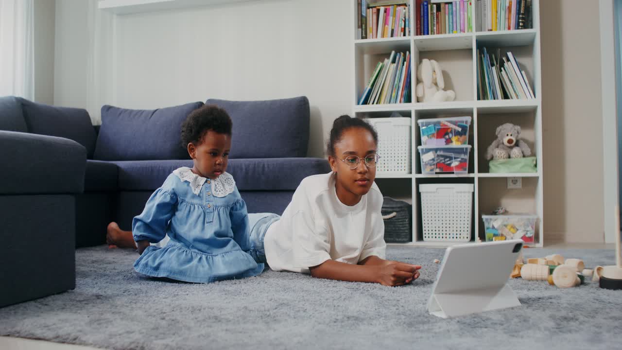 hermanas viendo la tableta en la sala de estar